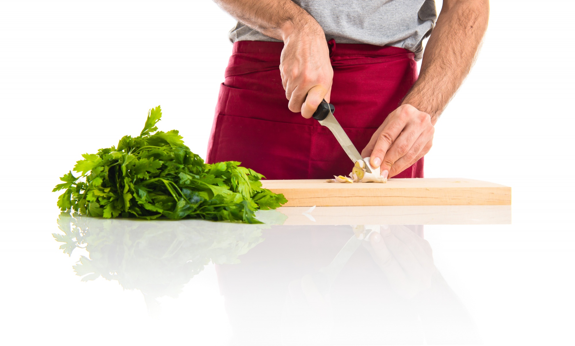 chef slicing herbs on cutting board